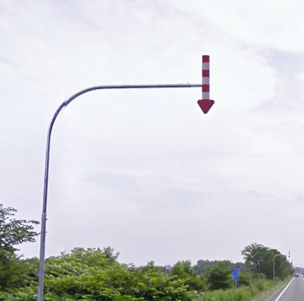 Utility pole with red and white striped arrow pointing downwards.